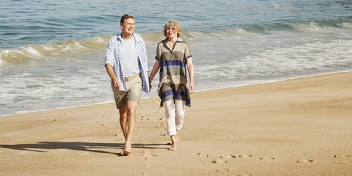 Couple walking on the Nazare beach holding hands, Portugal
