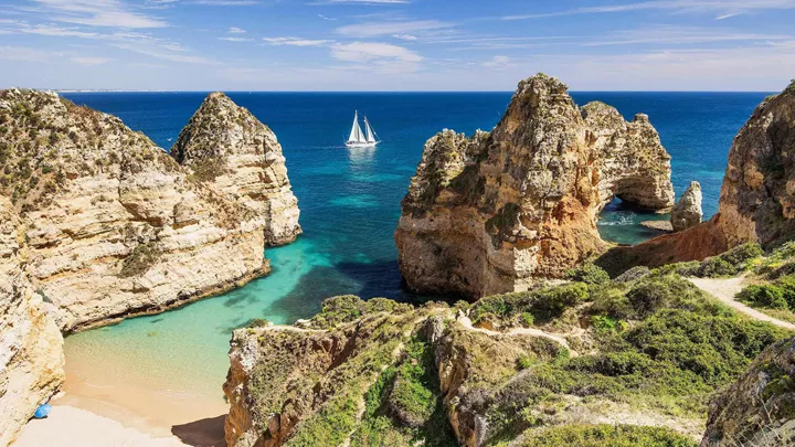 Beach and ocean with boat in Algarve, Portugal
