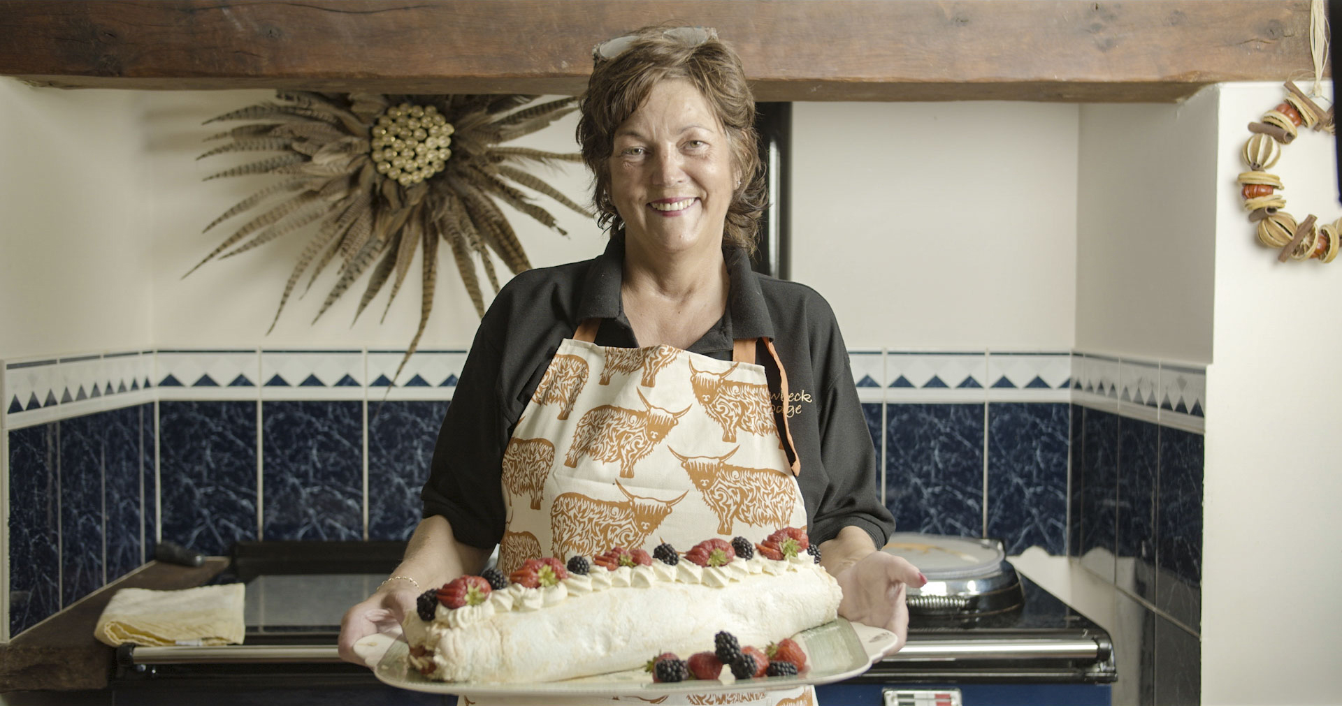Be My Guest host Anne Stobart holding a handmade dessert in Cumbria, England
