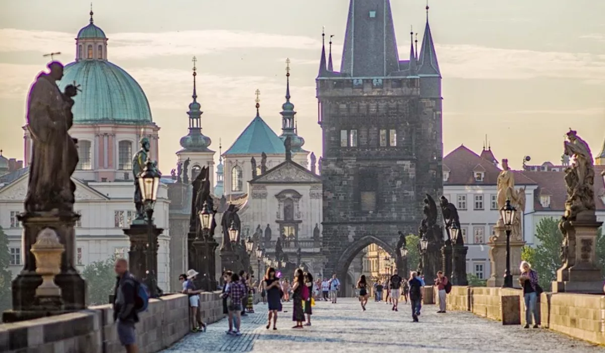 A group of people walking across Charles bridge, Prague
