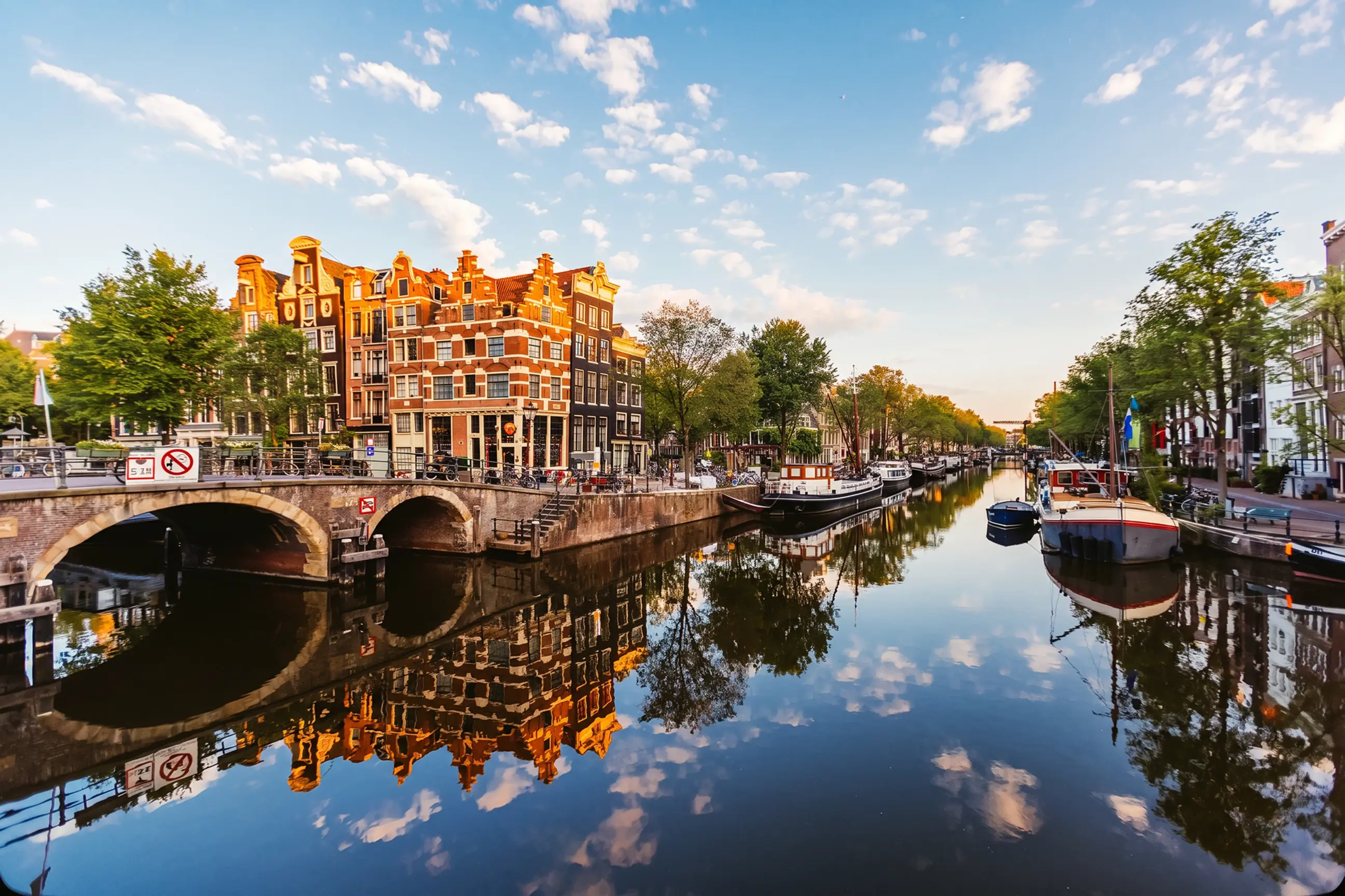 day-hero-traditional-dutch-houses-reflecting-in-the-canal-amsterdam-netherlands-1407111882.webp