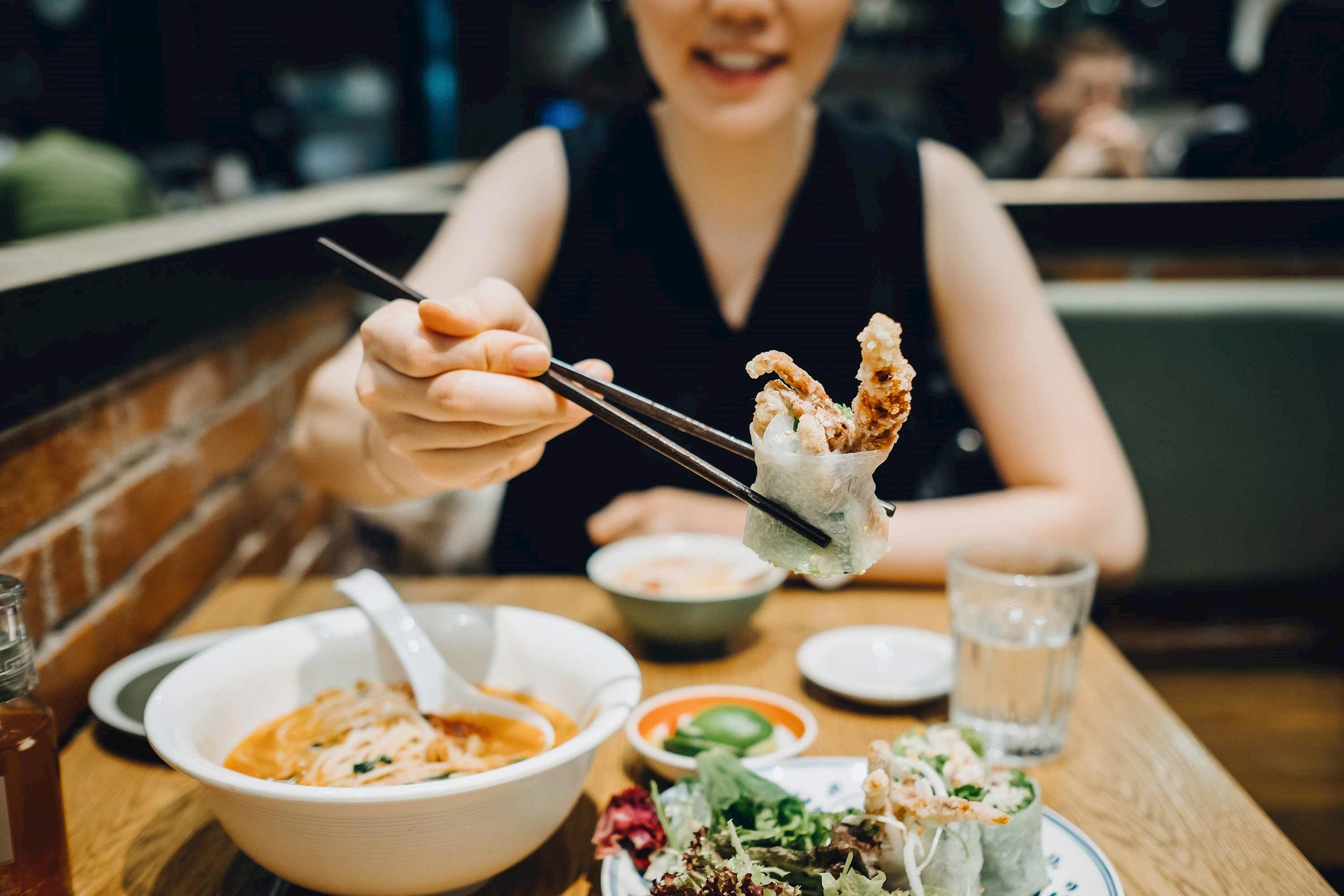Woman eating food in Hoi An, Vietnam