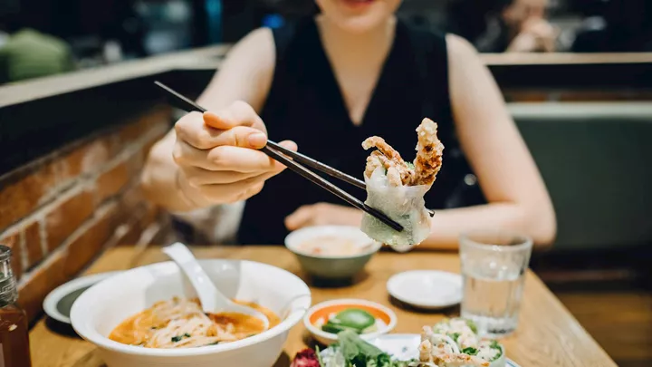 Woman eating food in Hoi An, Vietnam