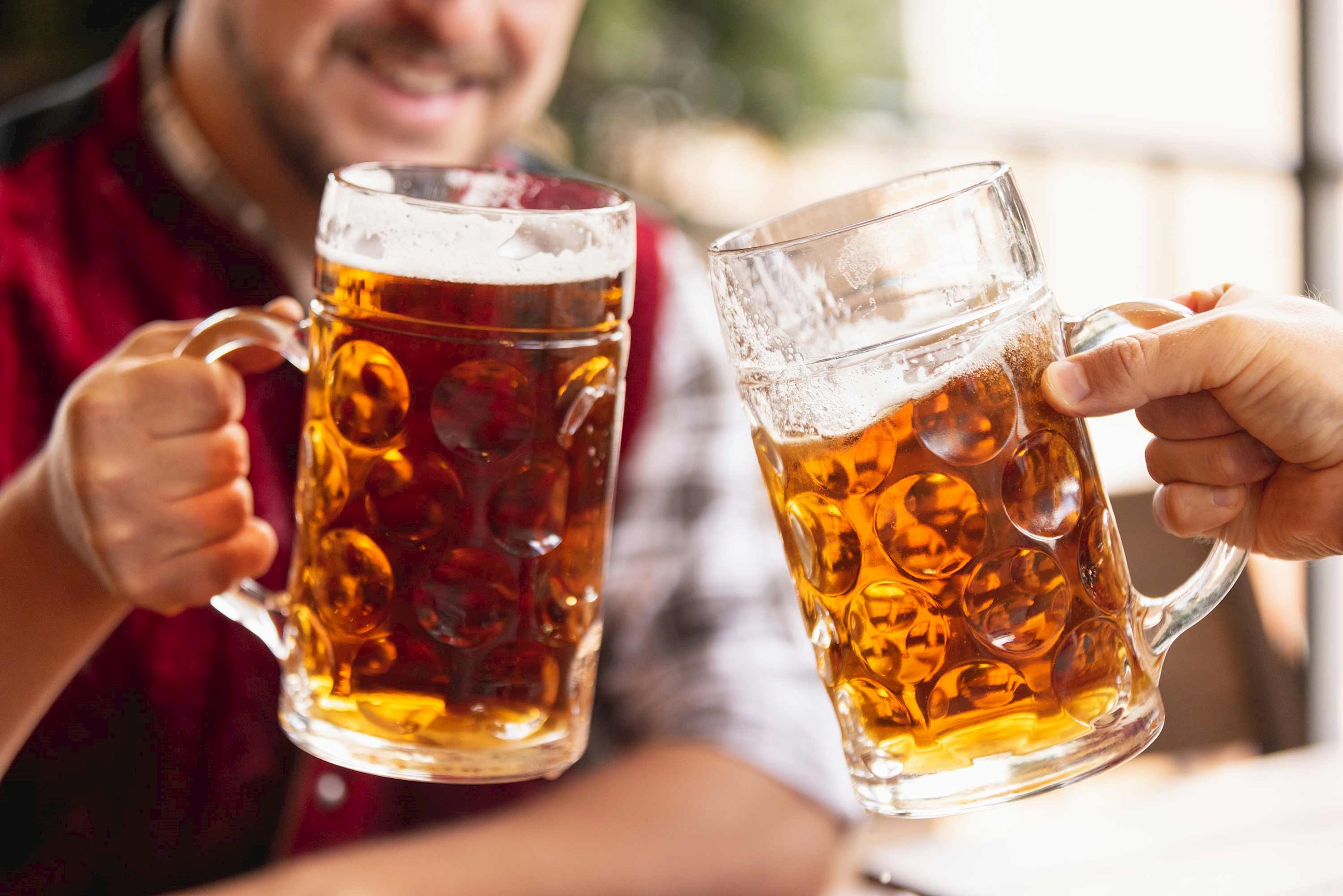 Two people clinking beer glasses at a Bavarian restaurant