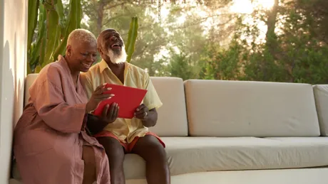 Older couple laugh with a digital tablet