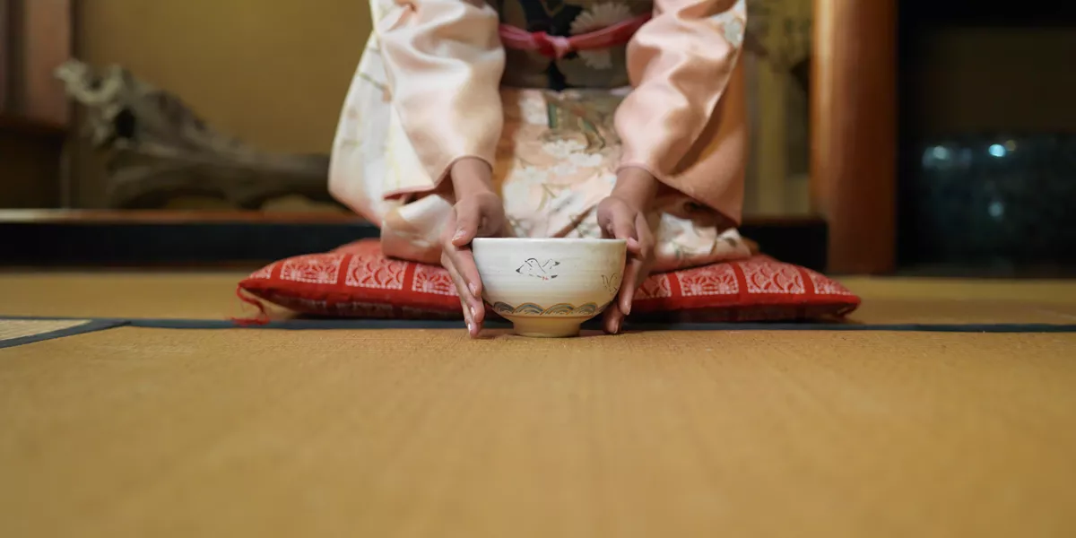 Woman Kneeling Down and holding a Tea Bowl