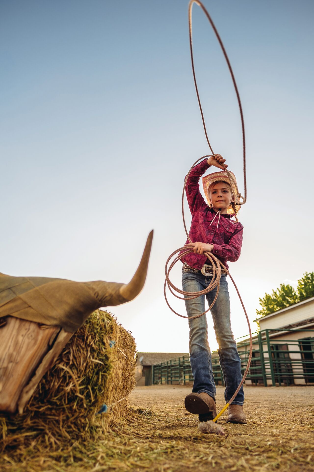 Child playing with a lasso while dressed as a cowboy 