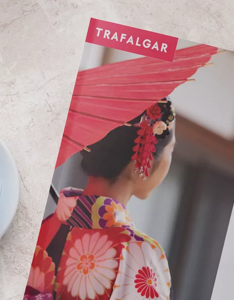 Trafalgar worldwide brochure next to a cup of coffee