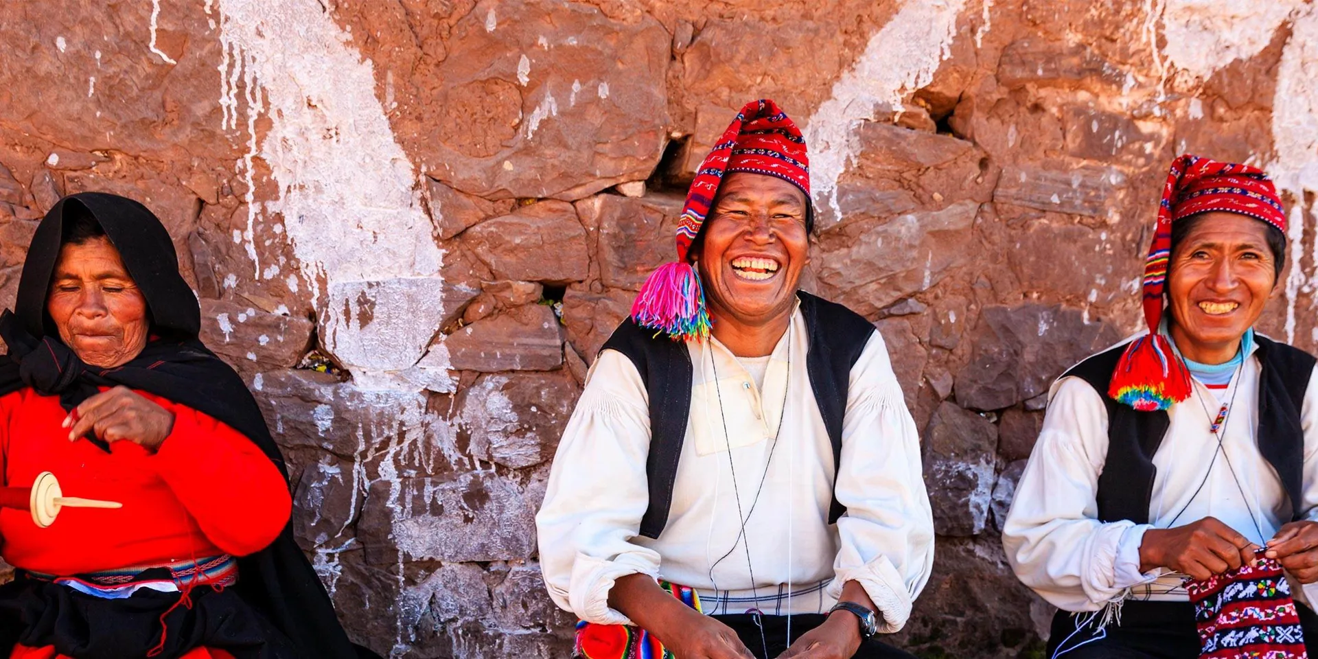 Three people knitting using traditional Peruvian techniques