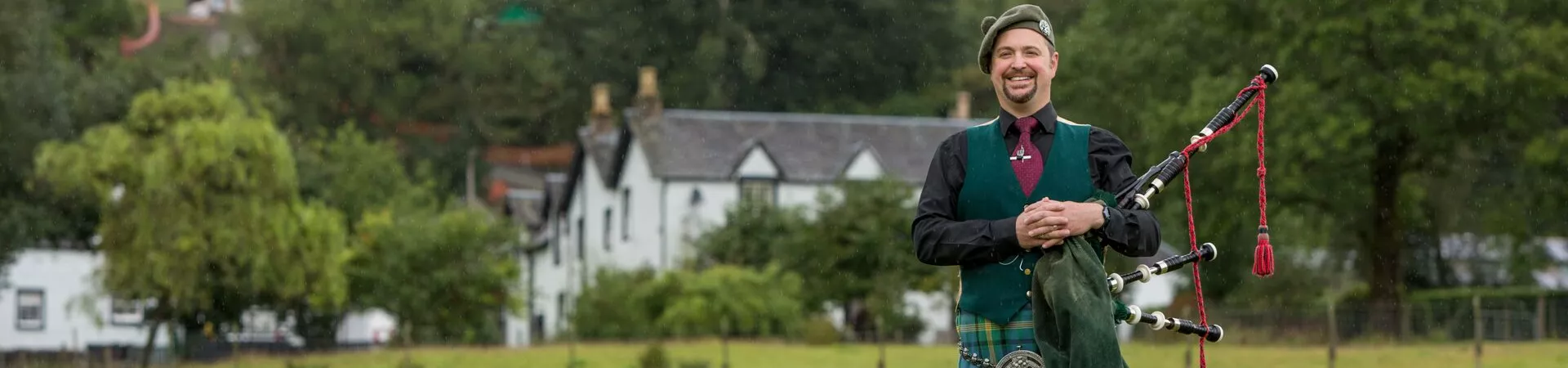 Traditionally dressed Bagpiper on a farm as part of a Trafalgar Be My Guest experience