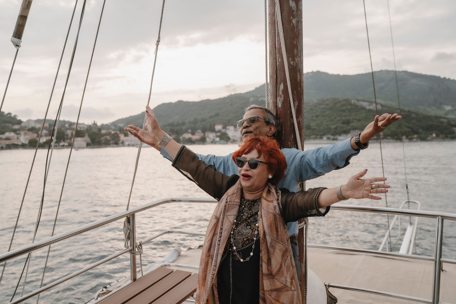 Couple posing on a boat in mountain bay in Balkans