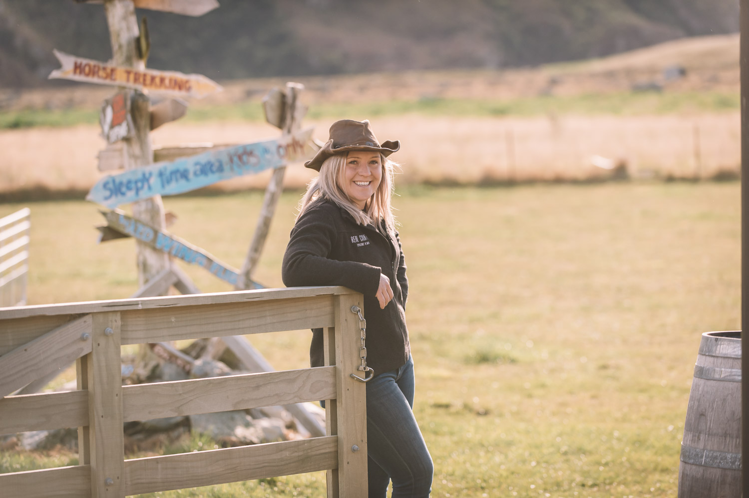 Laura from Real Country Farm in New Zealand standing next to fence