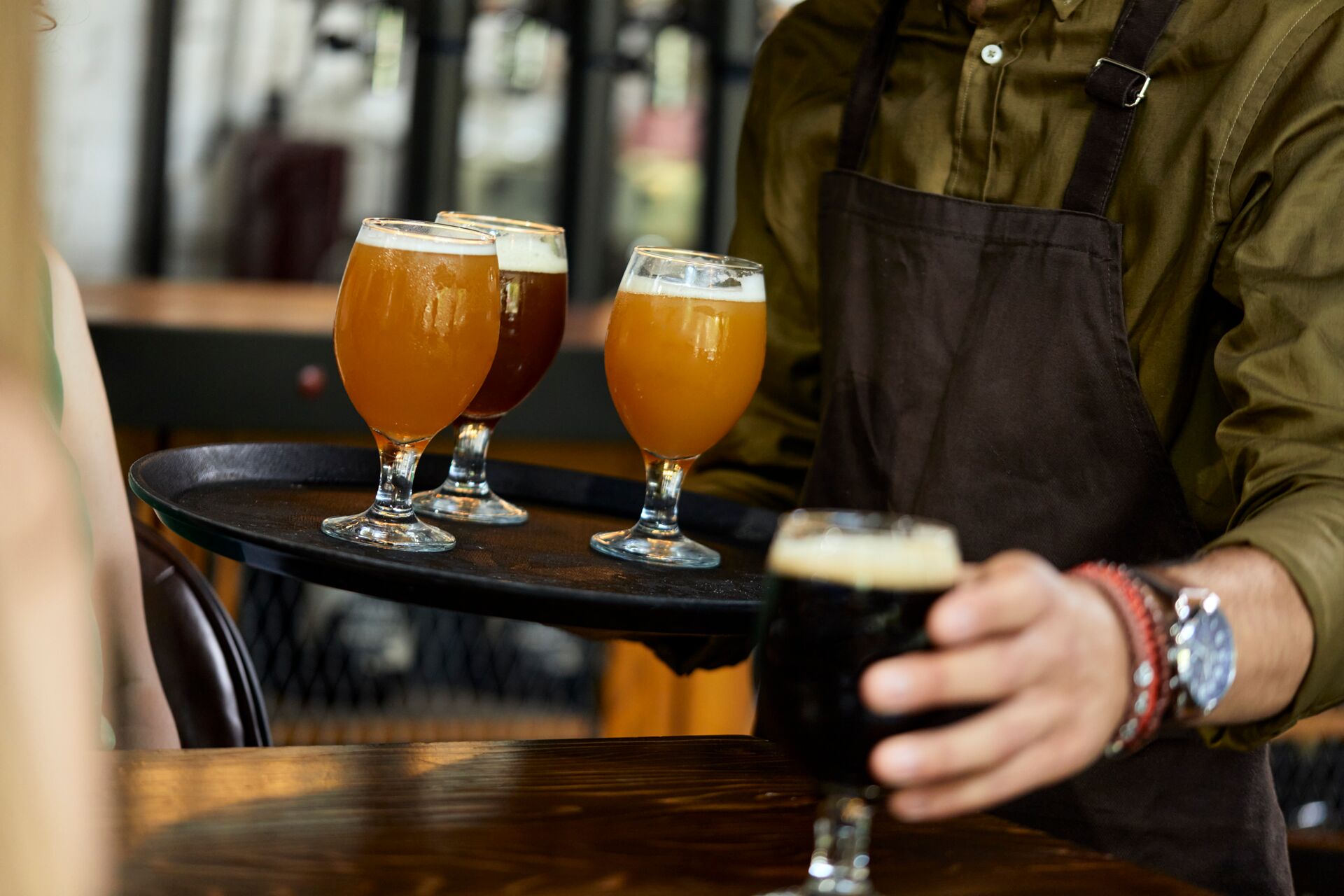 Waiter serving a variety of craft beer in a pub