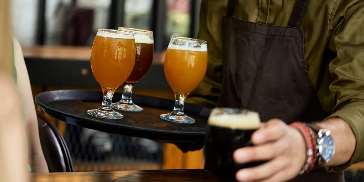 Waiter serving a variety of craft beer in a pub