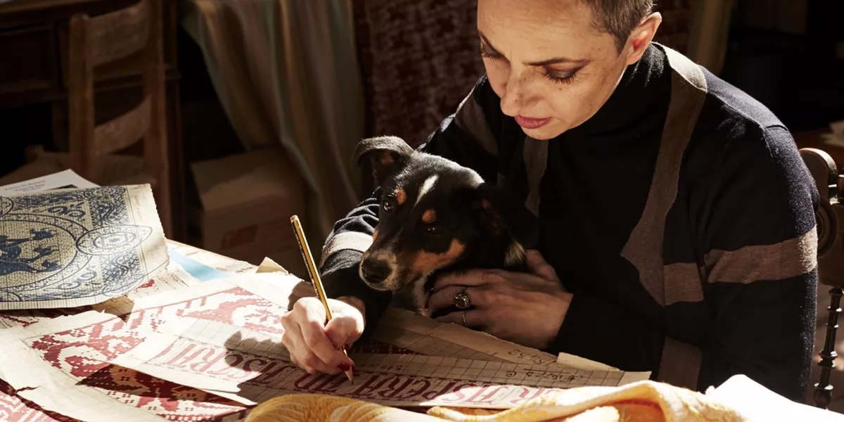 Marta Cucchia drawing with a dog on her laps
