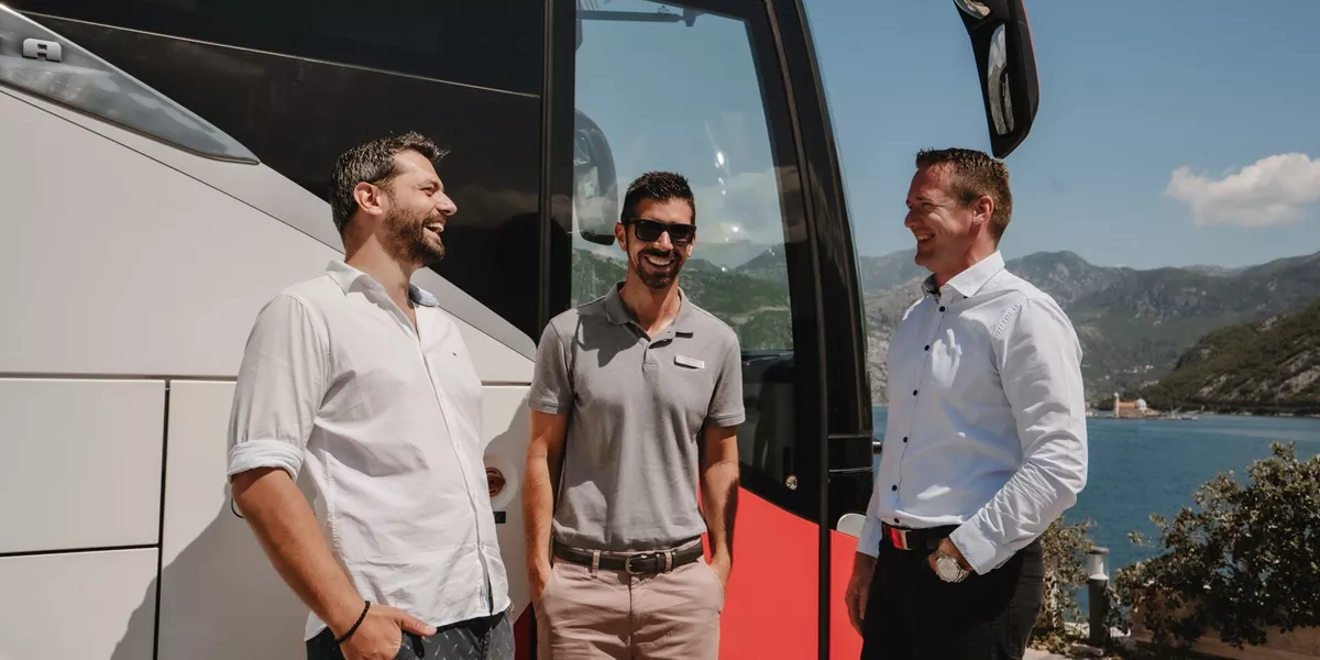Guests talking to their guide while next to a Trafalgar Coach