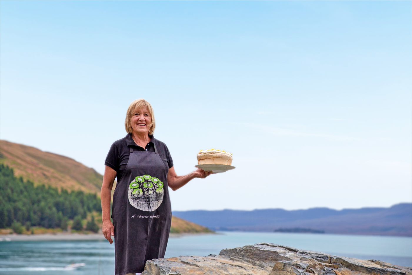 Angie Lake Tekapo holding a plate with cake at the bay, Australia