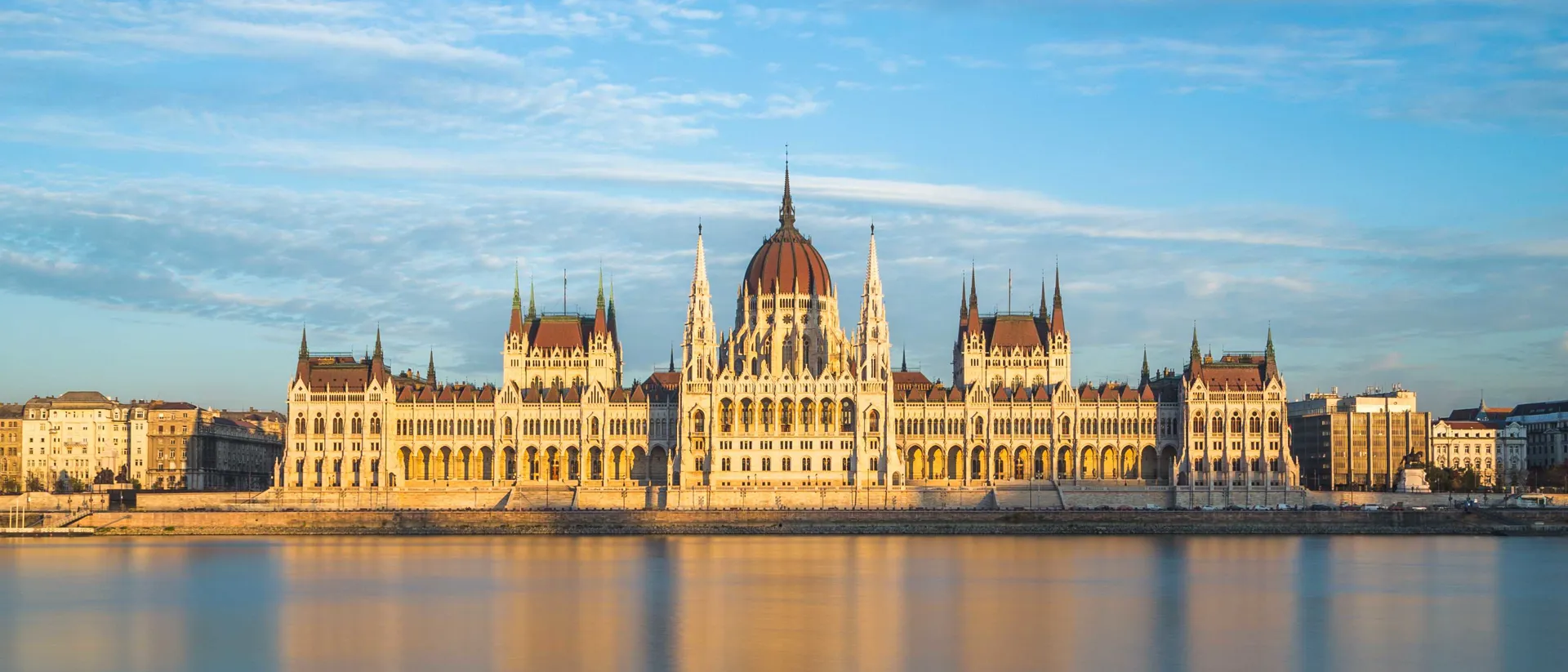 Hungarian Parliament in Budapest, reflected in a beautiful orange-hued river