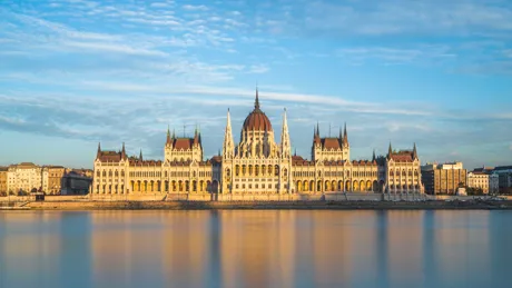 Hungarian Parliament in Budapest, reflected in a beautiful orange-hued river