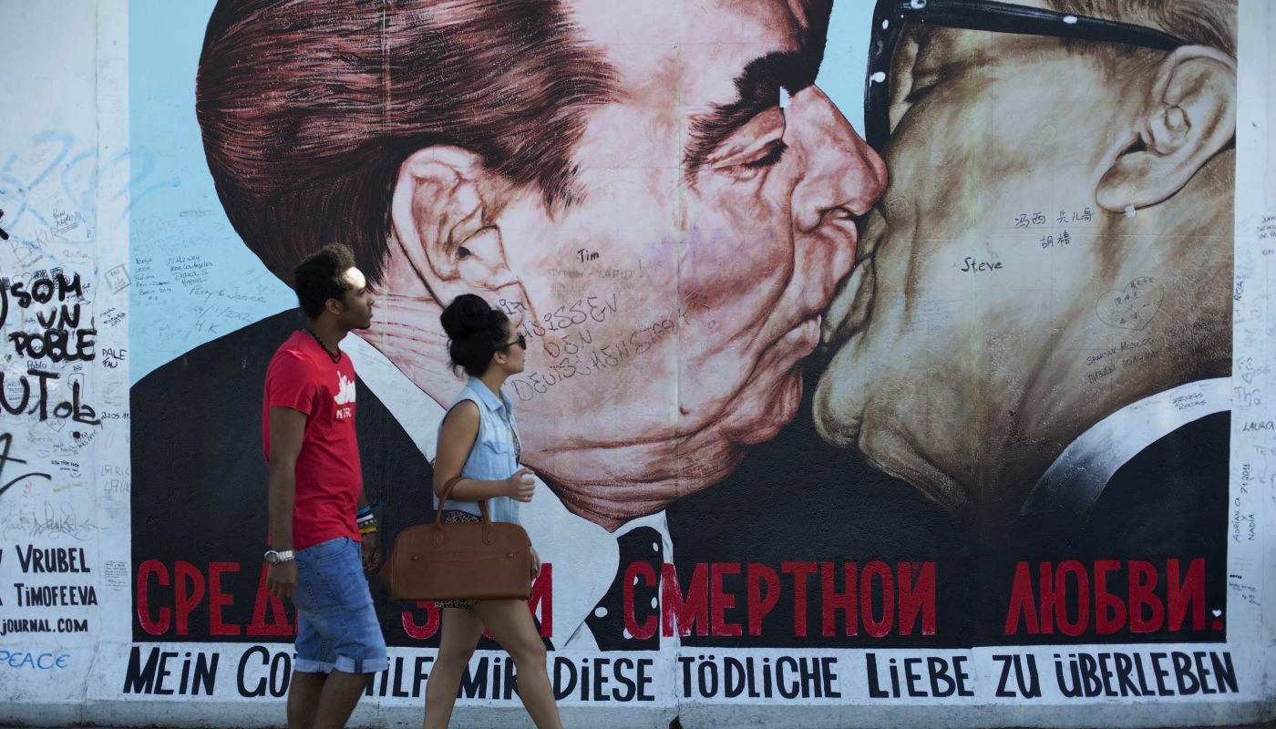 Couple walking near to mural Berlin