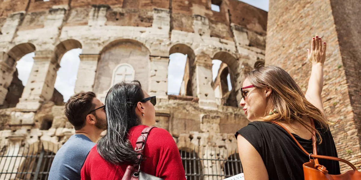 Tour guide explaining to tourists the Coliseum of Rome in Italy