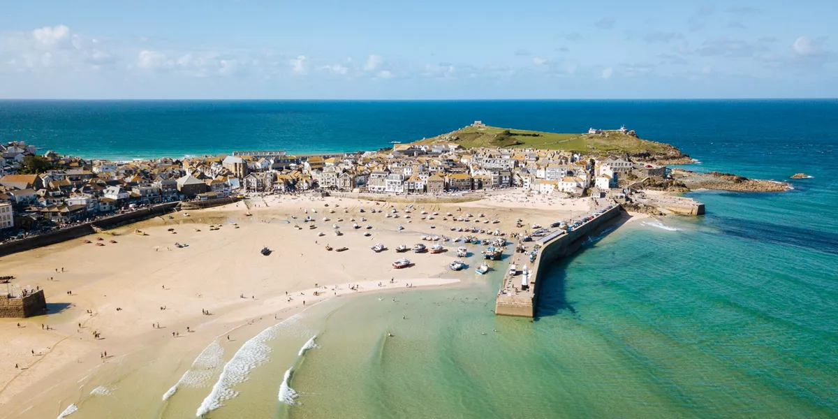 Aerial View of St Ives, a wide sandy beach and sheltered harbour with boats