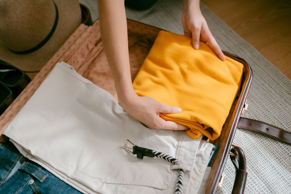 view-from-above-of-the-hands-of-woman-stuffing-clothes-into-a-suitcase.jpg