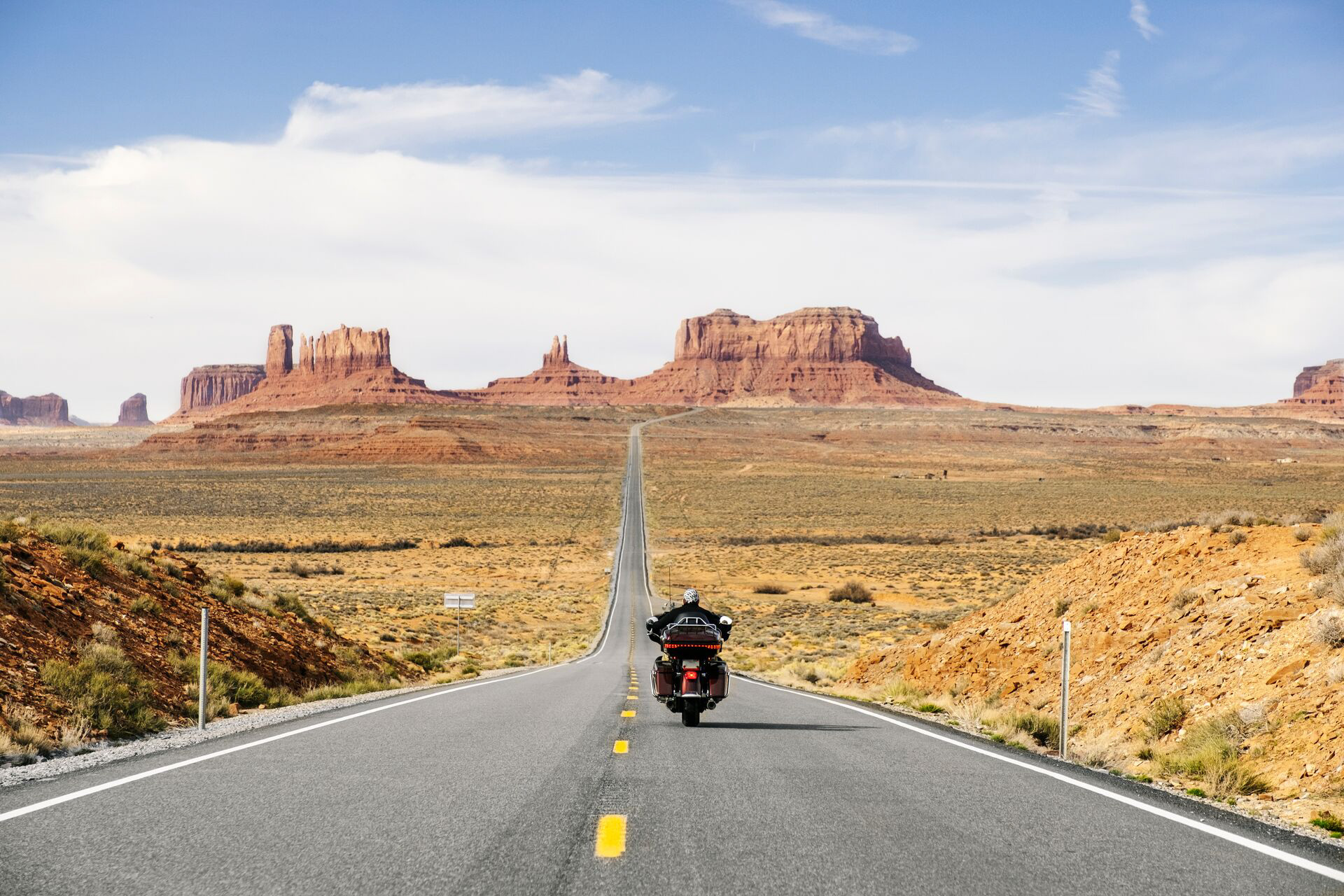 Rear View Of Man Riding Motorcycle On The Desert Road, Monument Valley Tribal Park, Utah