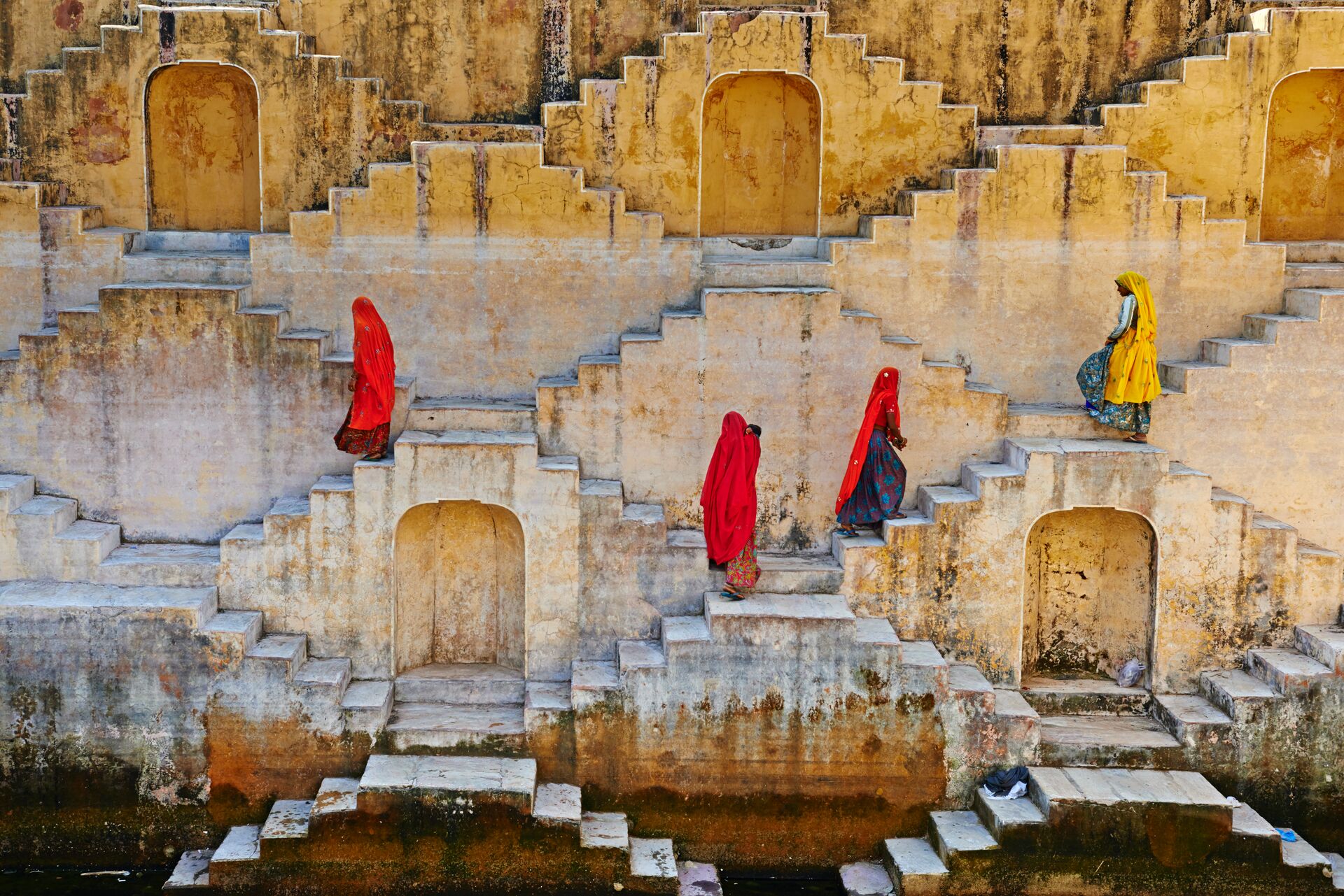 Women walking up steps in a traditional water tank in Jaipur, Rajasthan, India