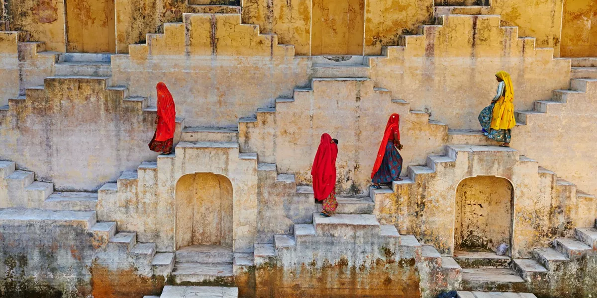 Women walking up steps in a traditional water tank in Jaipur, Rajasthan, India