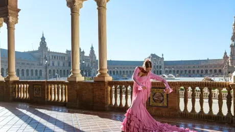 A dancer in a pink dress on Plaza de España balcony