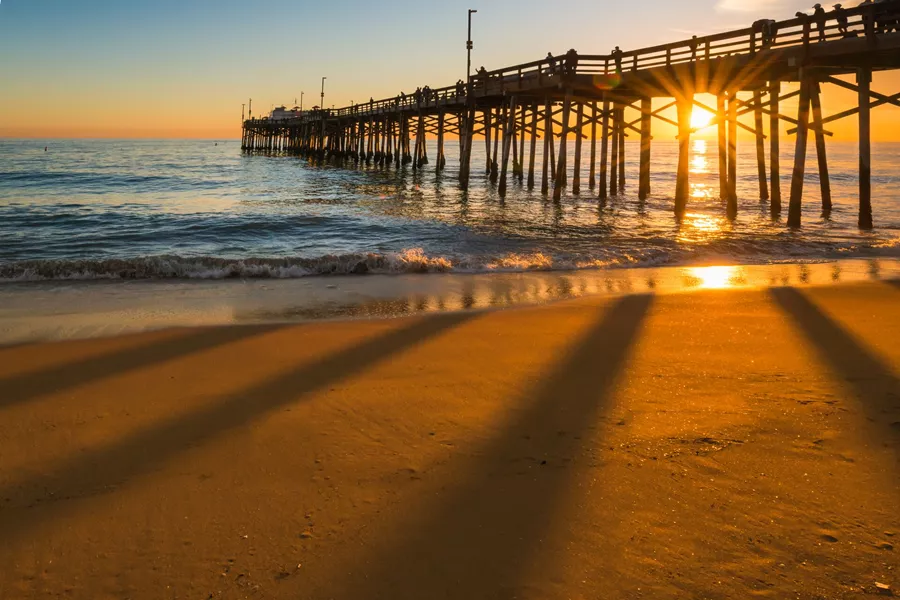 Sun setting behind a pier in California, USA