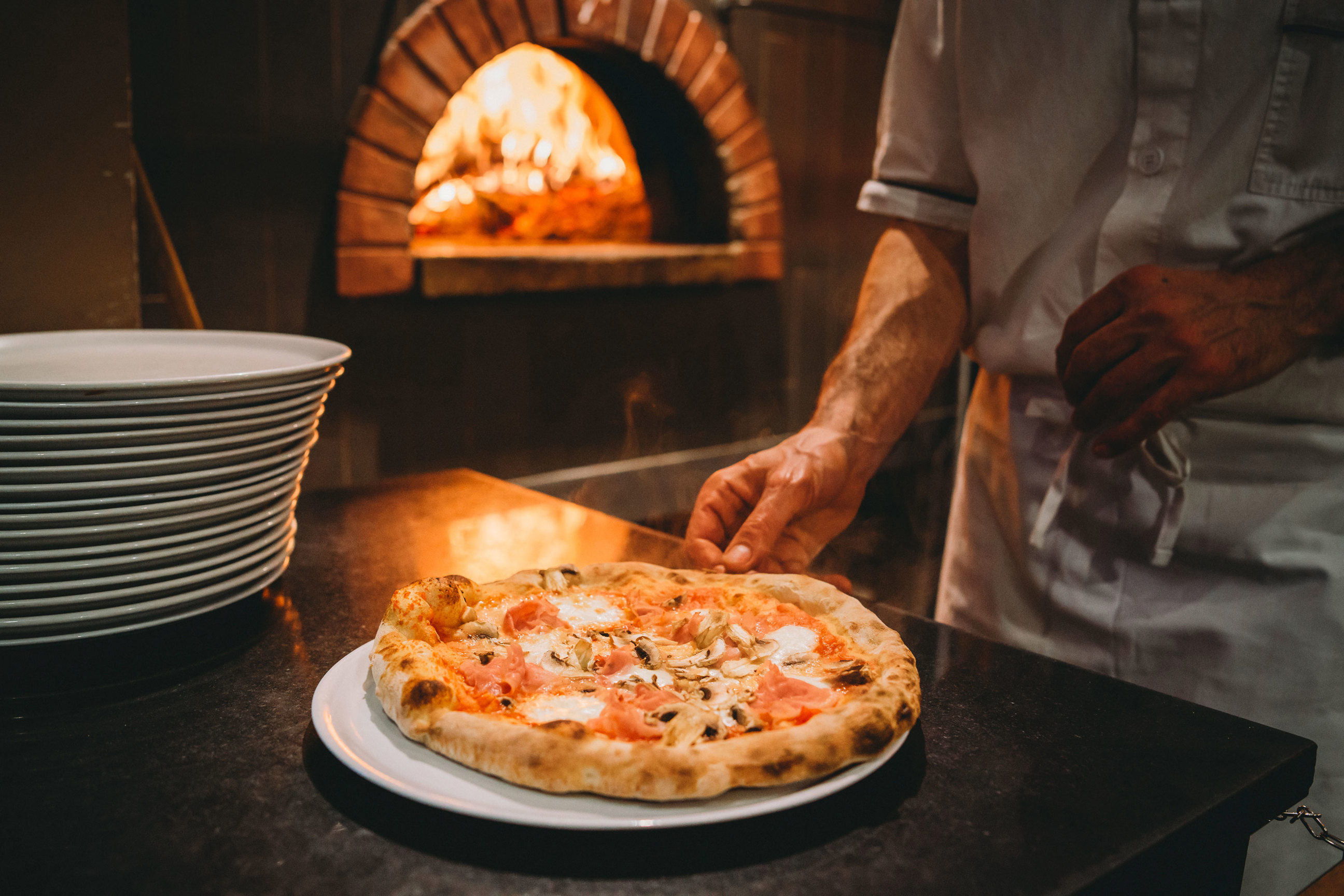 A pizza that was just taken out of a woodfire oven in Italy