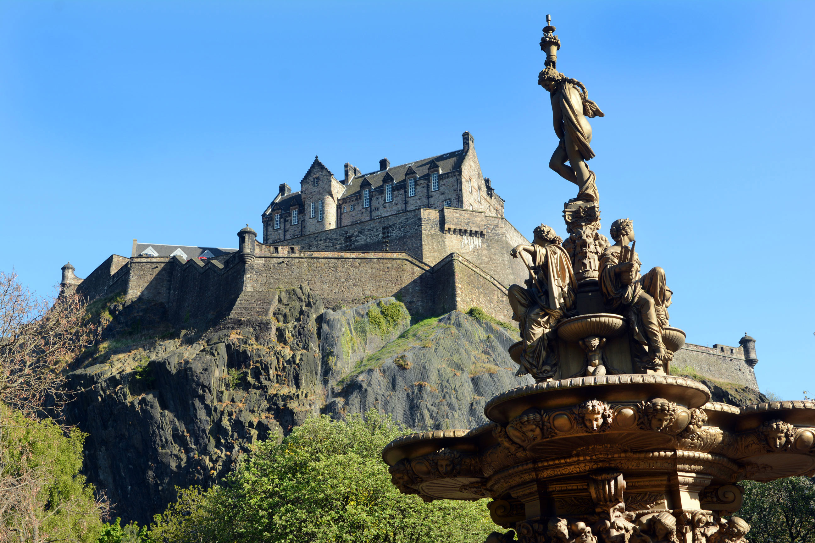 An uphill view of Edinburgh Castle and Ross Fountain