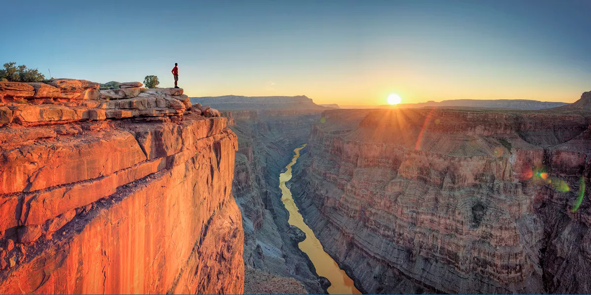 A man standing on the edge of a cliff in Grand Canyon