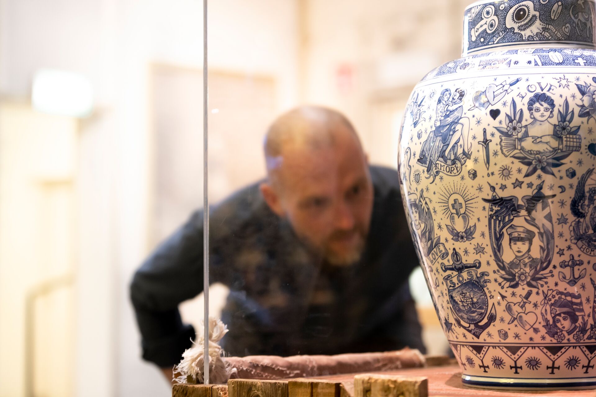 Man looking at white and blue vase
