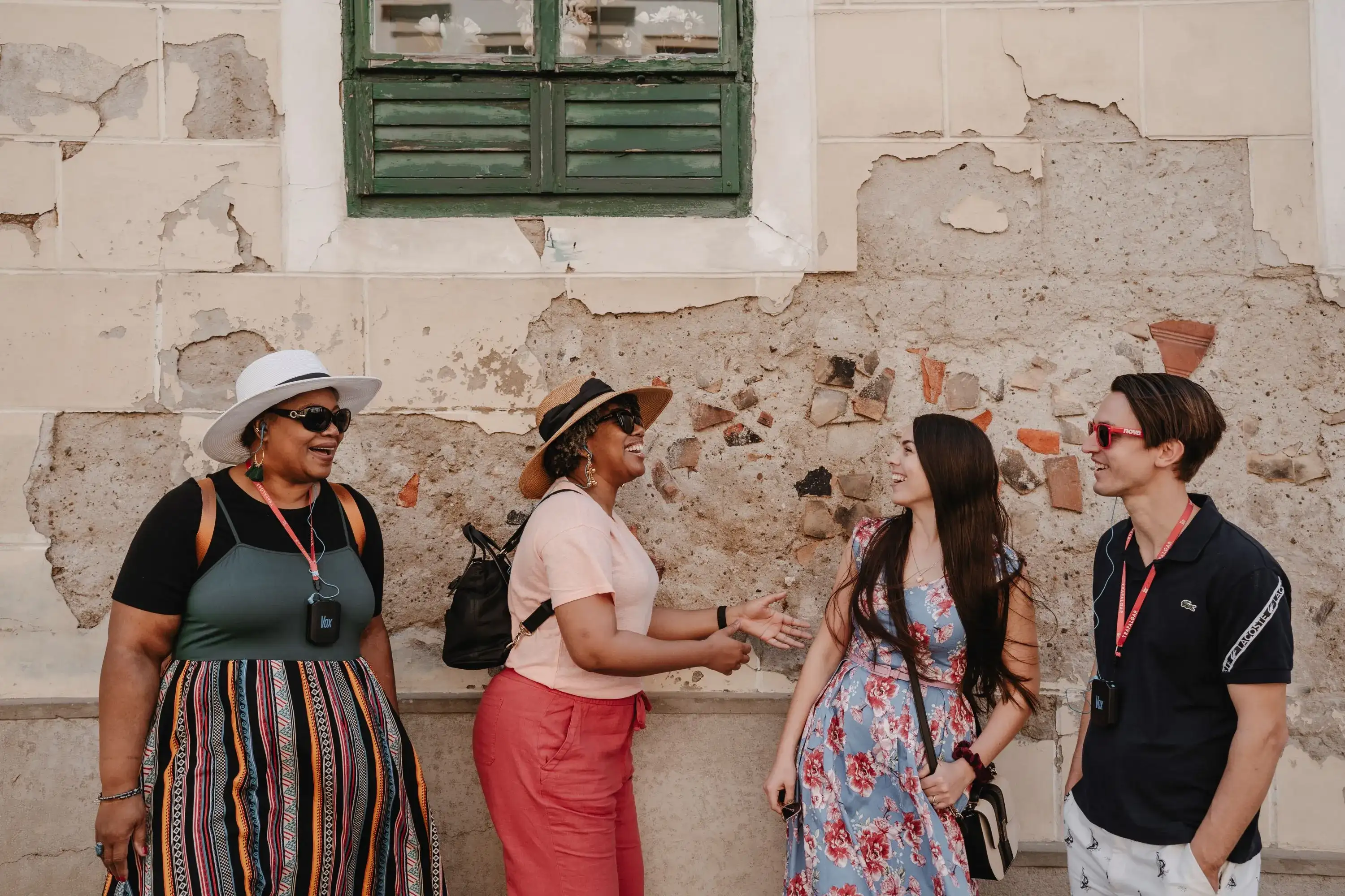 Smiling people stand near the wall