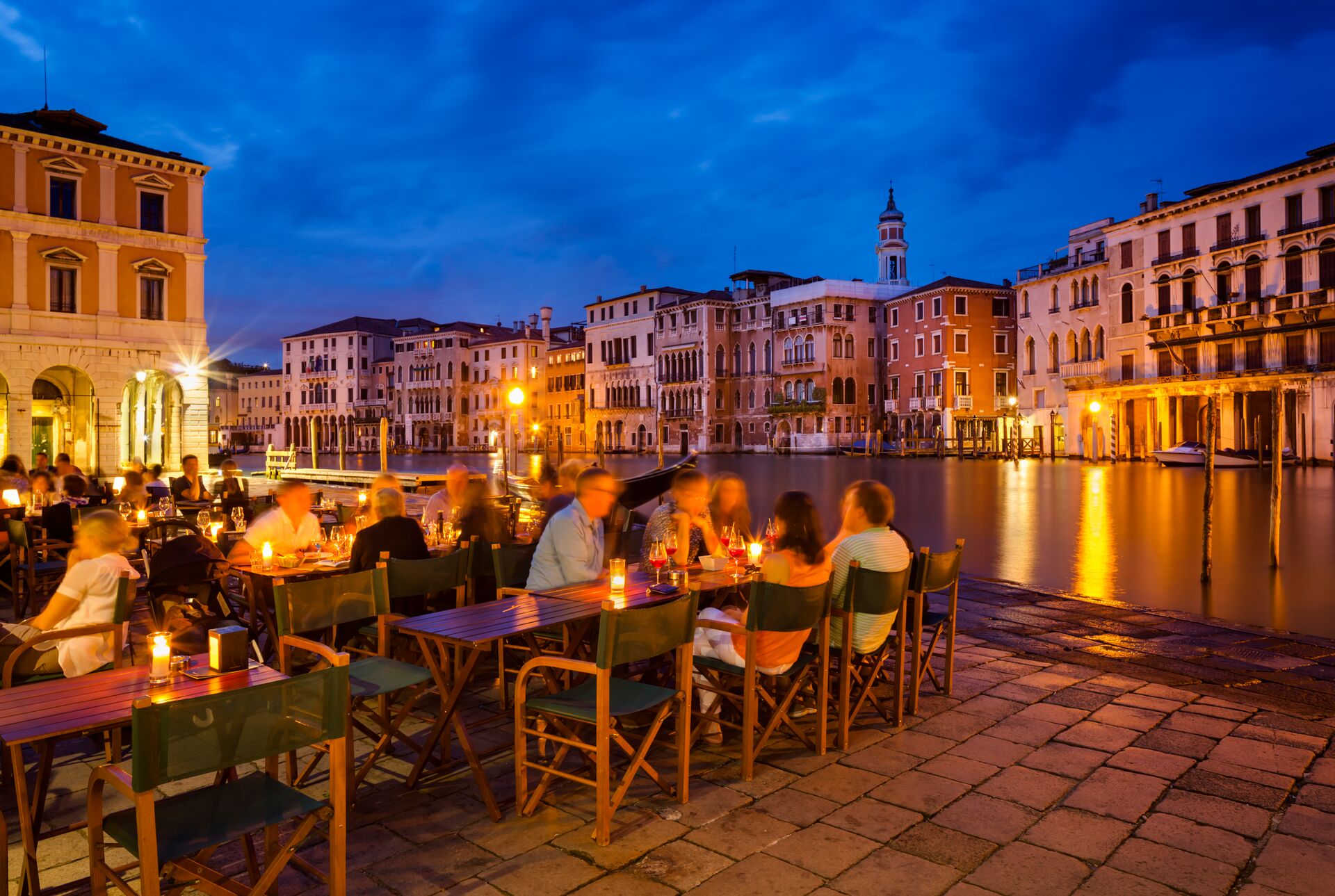 People eating dinner at dusk overlooking the Grand Canal in Venice, Italy