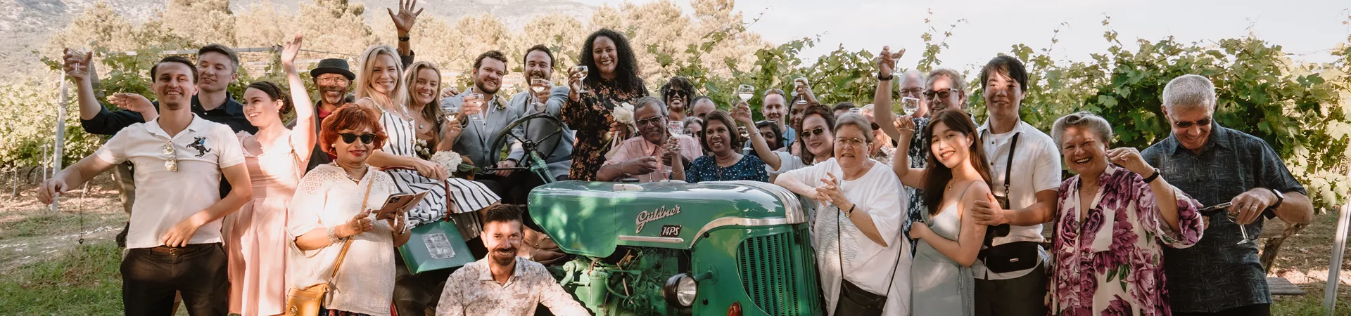 Multi generational group of travelers posing next to a tractor