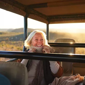 large-happy-senior-woman-on-safari-riding-in-off-road-vehicle-1365337910.jpeg