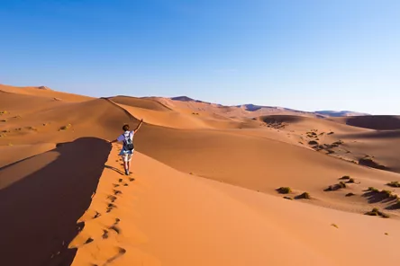 Woman walking on the Sand Dunes in Namibia, Africa