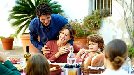 Family Enjoying A Meal At Outdoor Table In A Courtyard