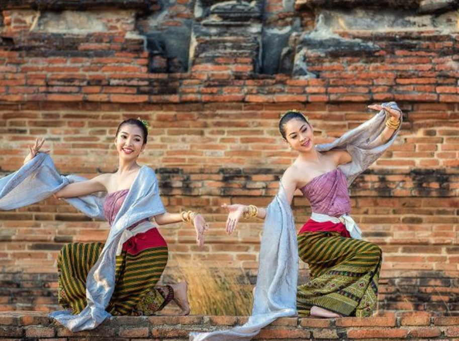 two-young-women-are-dancing-in-front-of-a-brick-wall.jpg