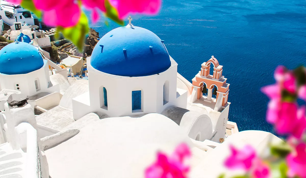A blue and white domed church overlooking the ocean in Santorini