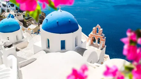 A blue and white domed church overlooking the ocean in Santorini