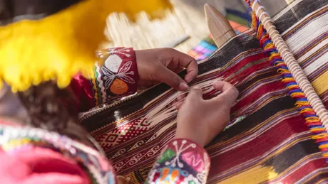 Hands of woman weaving on loom in Peru