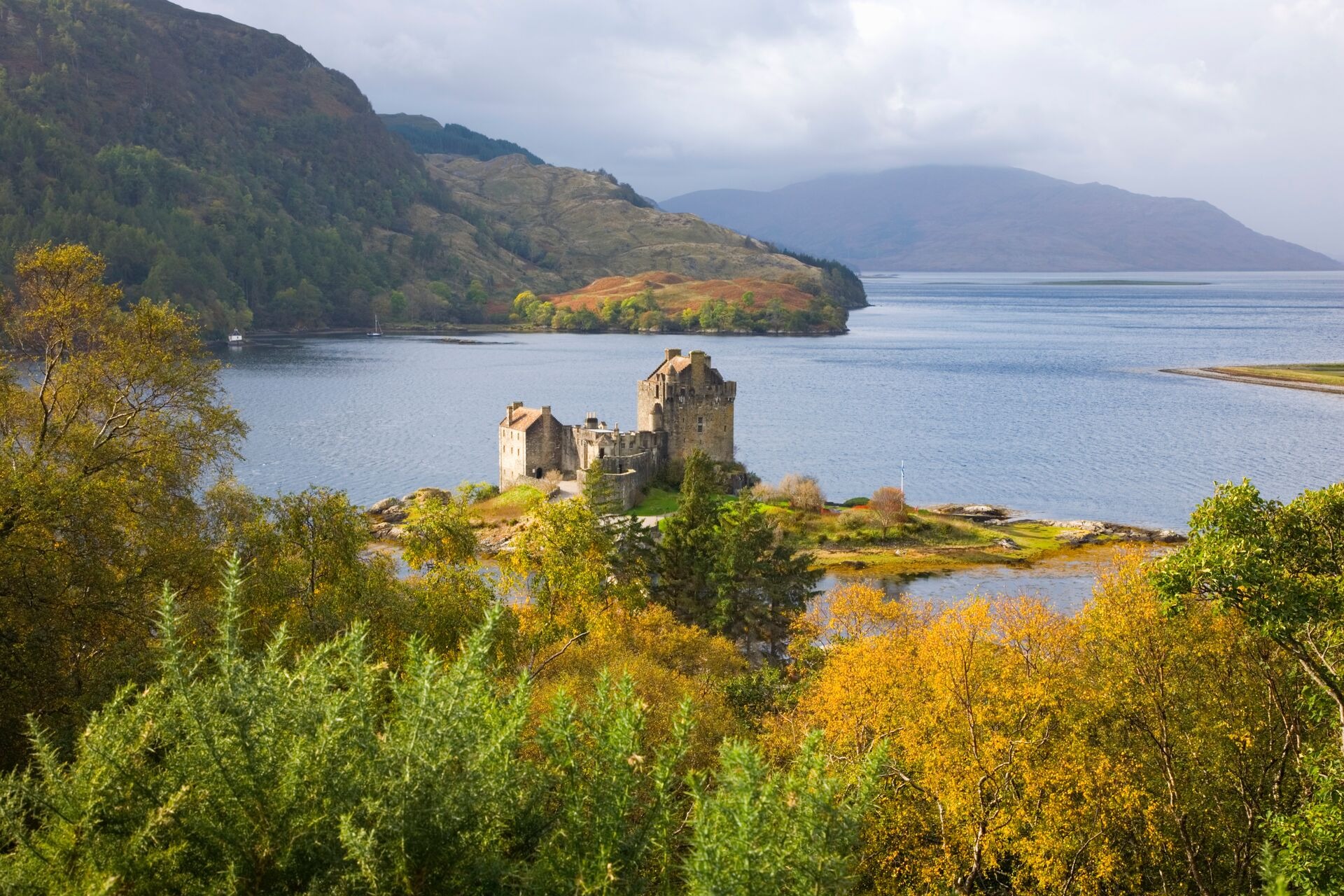 A Castle On A Small Island In The Middle Of A Lake In Scotland