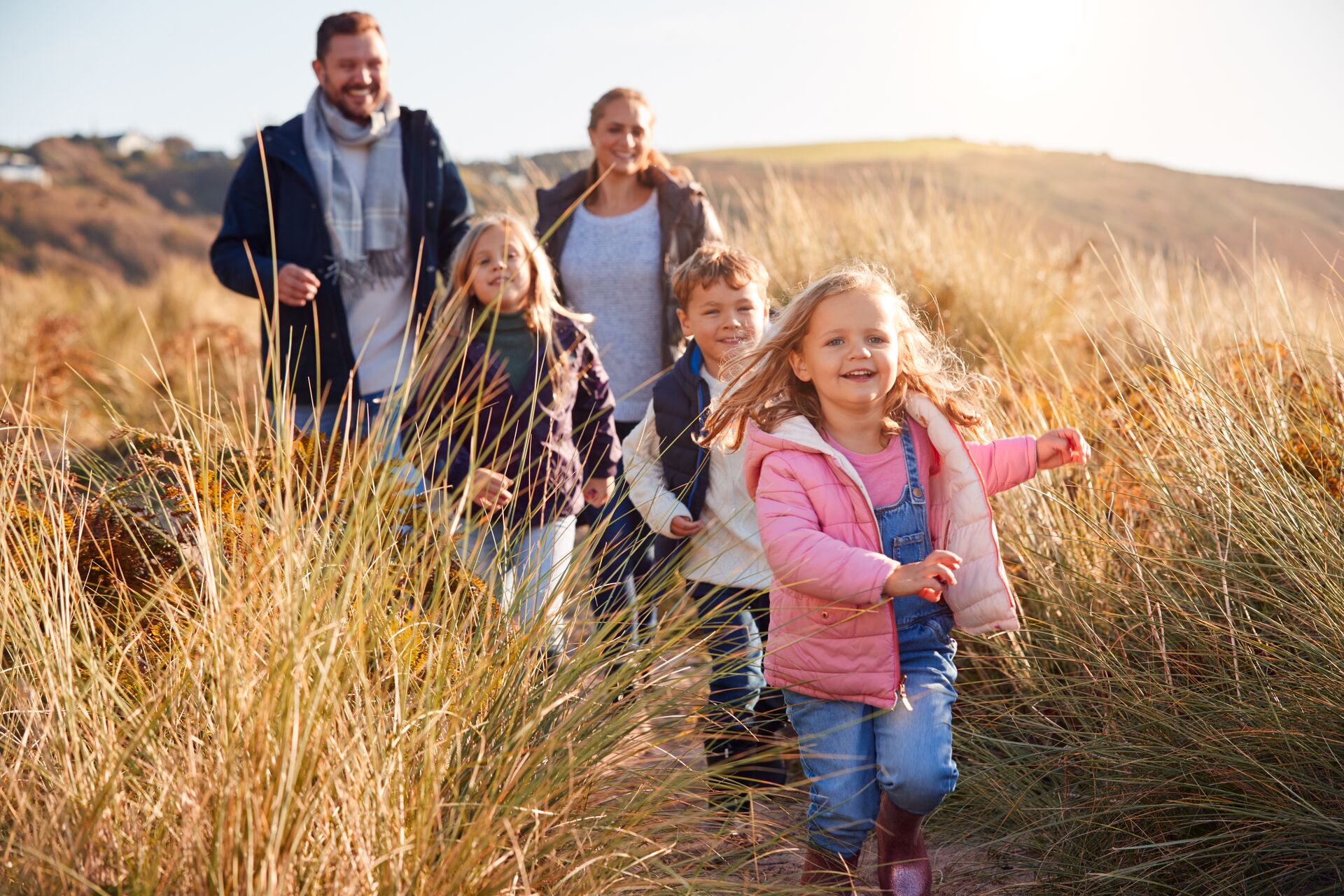 Family walking along path through sand dunes together