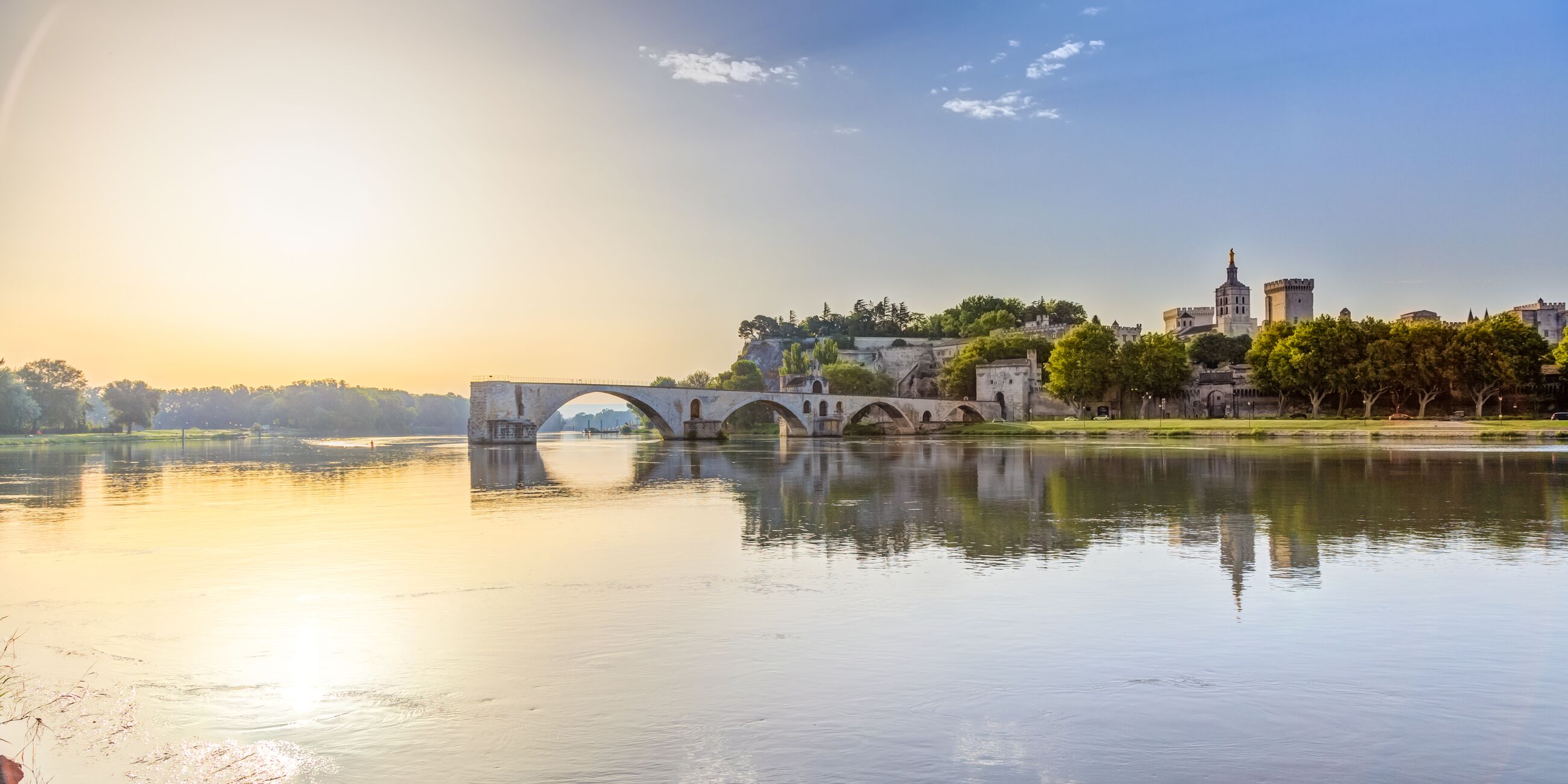 A bridge over a river with a city in the background