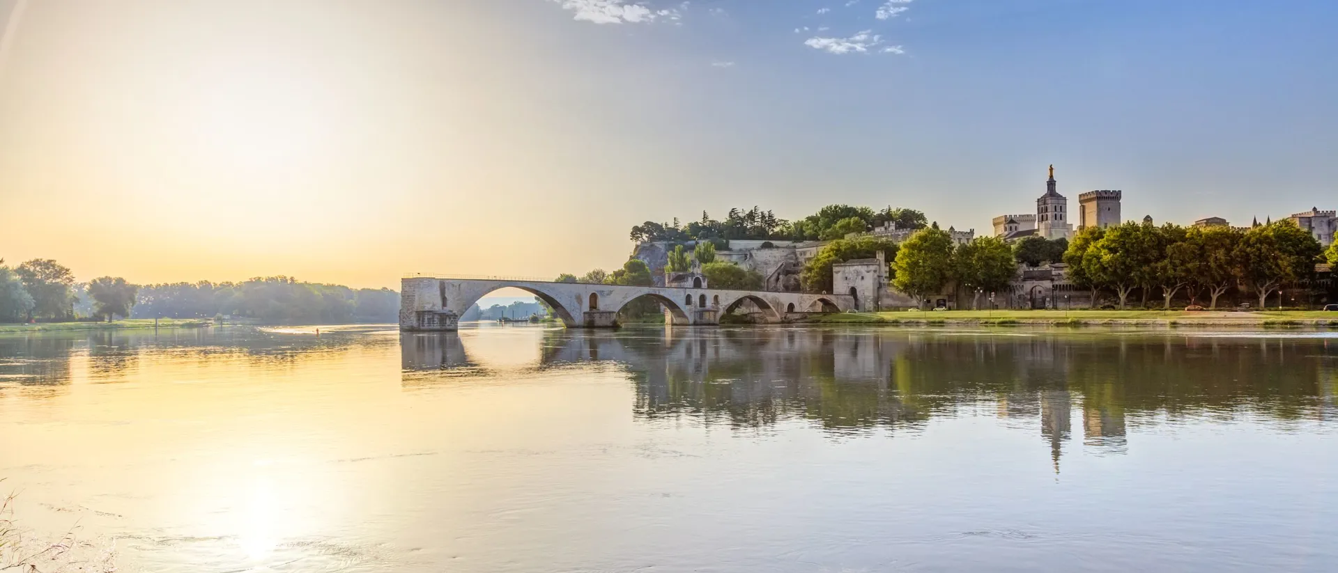 A bridge over a river with a city in the background